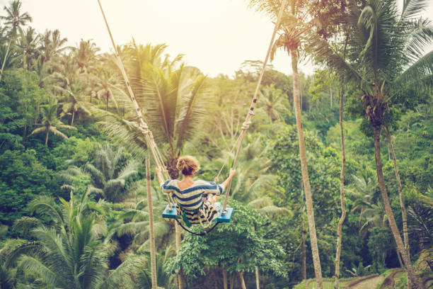 istock Young woman swinging over the jungle, Bali 952105290