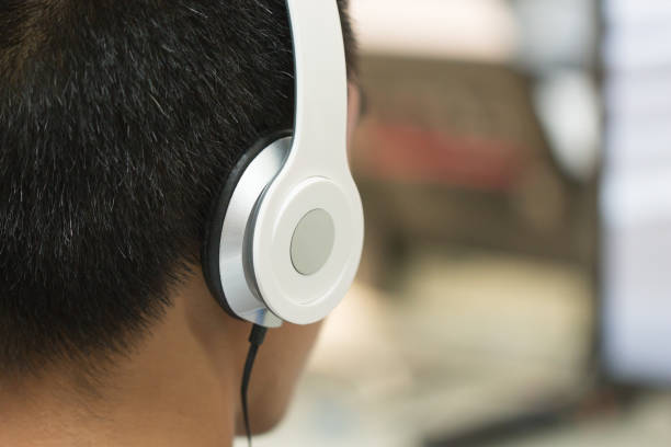 istock Education e-learning foreign languages Concept : Student Young man wearing Headphones listening English songs music and searching for learning abroad in classroon of university 952105328