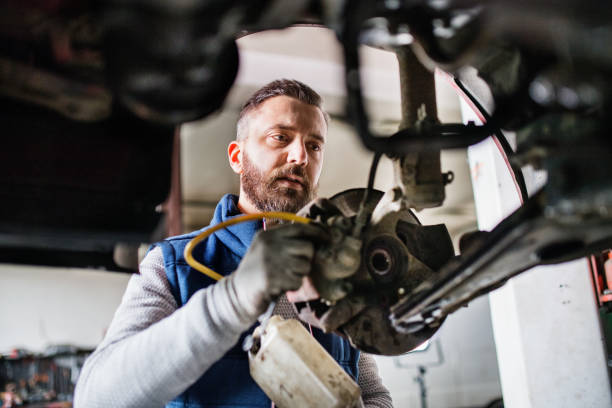 istock Man mechanic repairing a car in a garage. 952105526