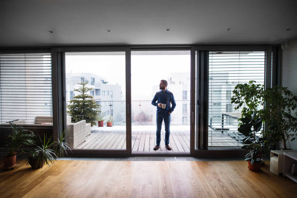 istock A man on a balcony holding a cup of coffee at home. 952112634