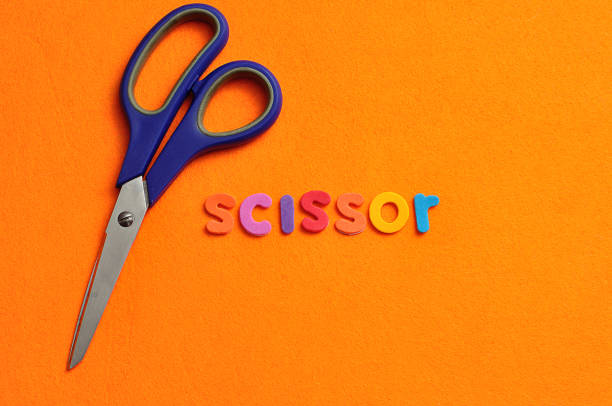 istock A scissor with the word scissor on an orange background 952113202