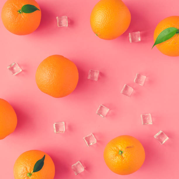 istock Creative summer pattern made of oranges and ice cubes on vivid pink background. Fruit minimal concept. 952114800