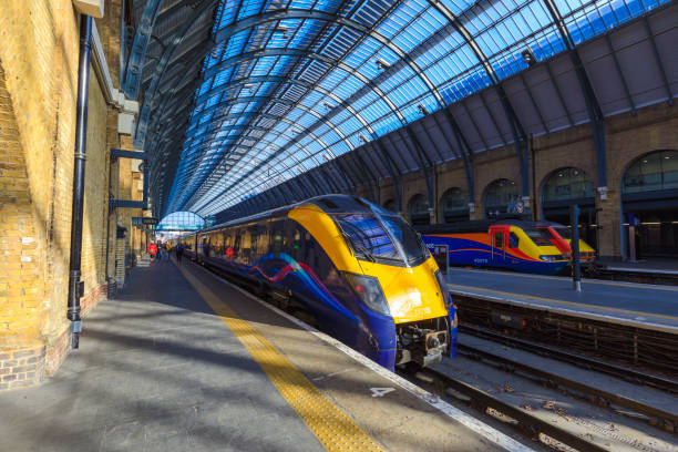 Horizontal color image of a busy railroad platform at Paddington station in London, UK.