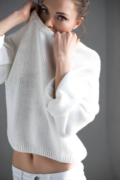 istock sensual young woman taking off white sweater and looking at camera on grey 952116422