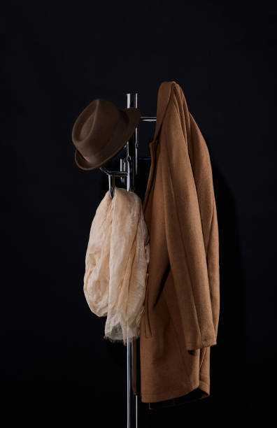 классический па�льто, шляпу и шарф висит на пальто стойку изолированы на черном - coat coat hook hatstand hanging стоковые фото и изображения