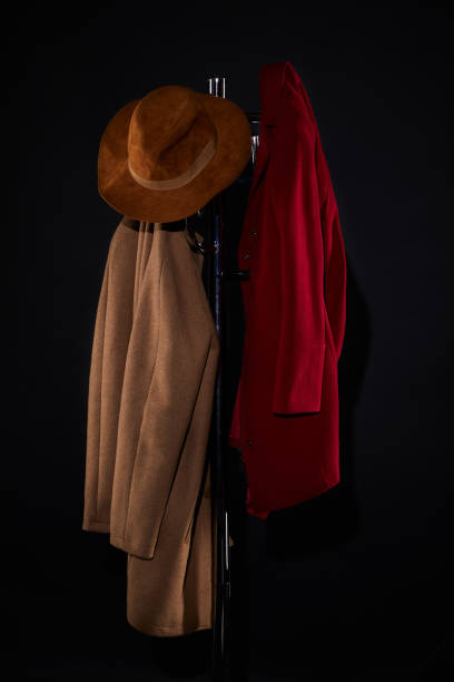 casacos e chapéu pendurado na revestir cremalheira isolada em preto - coat coat hook hatstand hanging - fotografias e filmes do acervo
