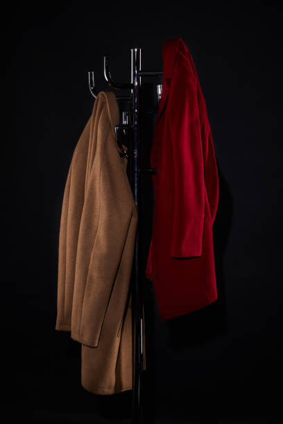 istock classic coats on coat rack isolated on black 952117668