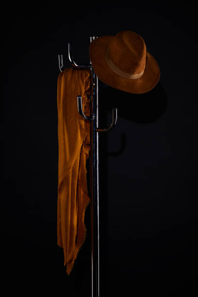 istock scarf and hat hanging on coat rack isolated on black 952117710