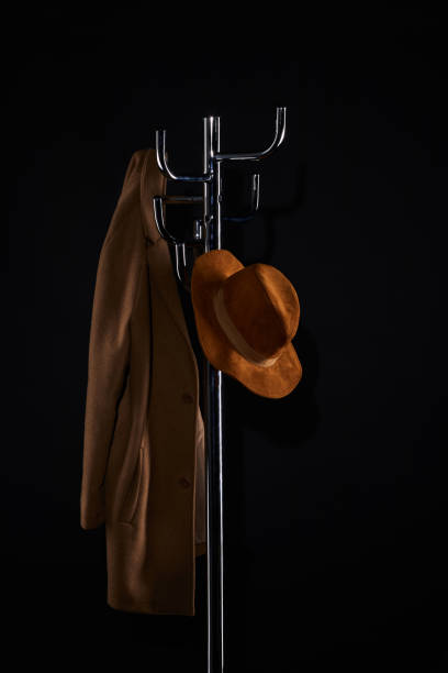 bonnet et manteau accroché portemanteau isolée sur fond noir - coat coat hook hatstand hanging photos et images de collection