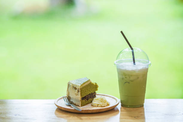 Green Tea and Green Tea Cake Placed on a wooden table by a glass window.Green Tea and Cake on green background.