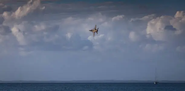Fighter jet banking hard over ocean
