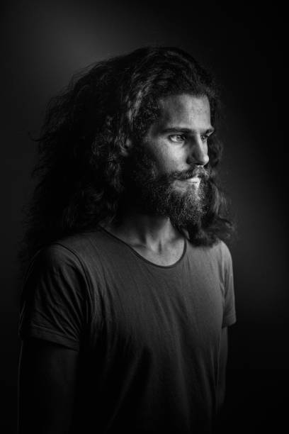 istock Young man with a beard and long curly hair 952121814