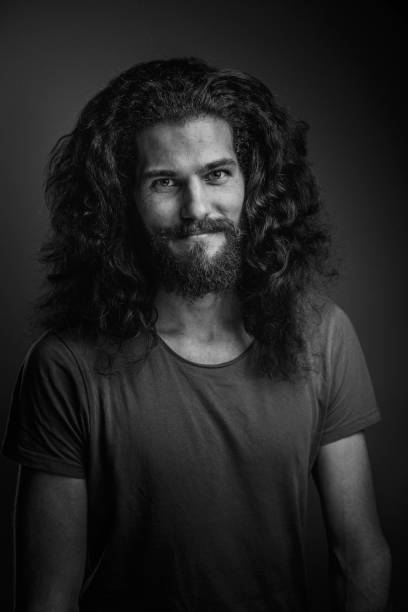 istock Young man with a beard and long curly hair 952122042