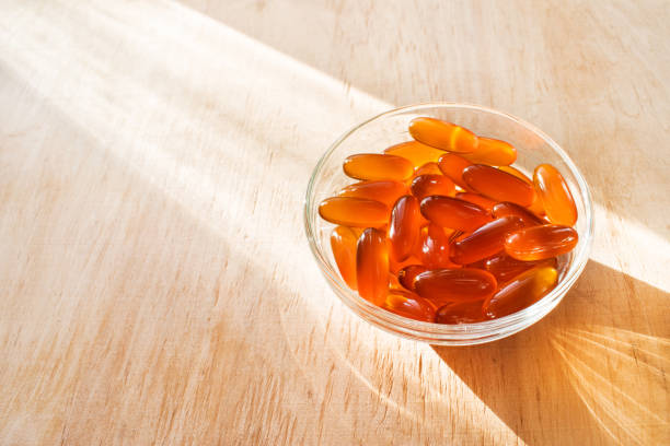 tabletki żelowe lecytyny w okrągłej szklanej misce ze światłem słonecznym na drewnianym tle - nutritional supplement capsule gel effect gelatin zdjęcia i obrazy z banku zdjęć