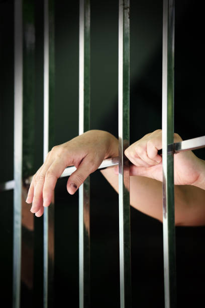 istock close up of prisoner hands in jail background 952251364