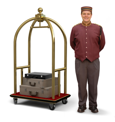 Bellhop in retro uniform and luggage cart on a white background with clipping path on bellman