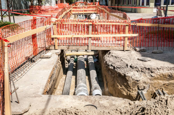 istock City district heating pipeline reparation and reconstruction parallel with the street with orange construction safety net or barrier around the excavation site with pipes 952297880