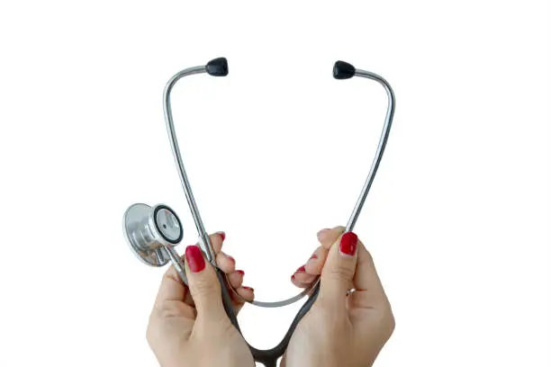 Closeup of female doctor hands holding a stethoscope, isolated on white background