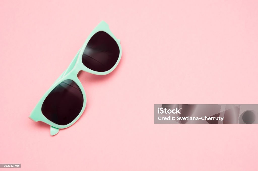 Green pastel sunglasses isolated on punchy pink, top view. Copy space. Summer concept. Green pastel sunglasses isolated on punchy pink background, top view. Copy space. Summer concept. Sunglasses Stock Photo