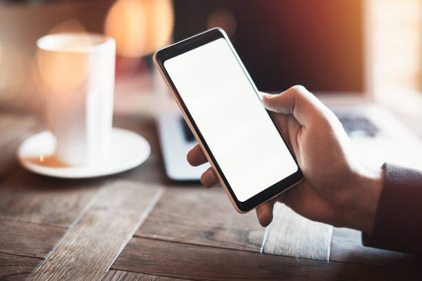 istock Young man holding mobile phone and drinking coffee with milk. 952312884