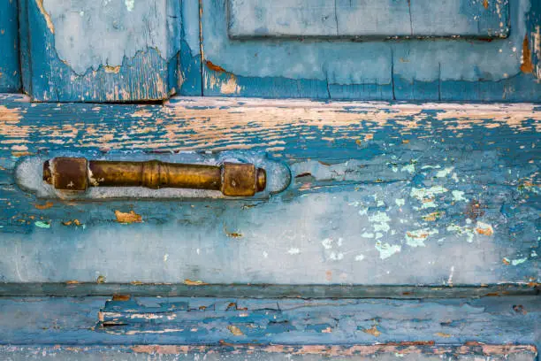 Yellow door handle of traditional old wooden blue door