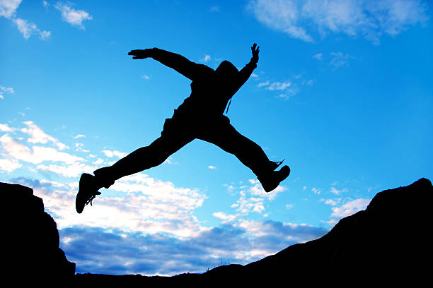 istock Silhouette of a jumping man under blue sky 95231567