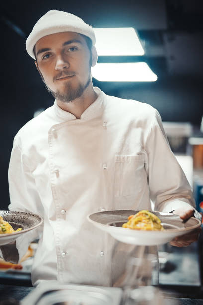 istock Restaurant Chef cook holding dish with pasta. 952322306