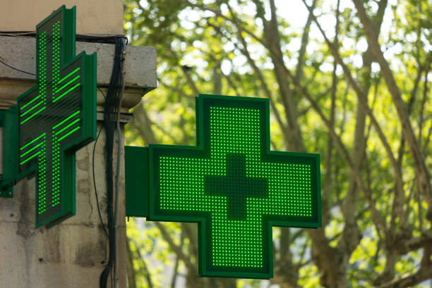 Pharmacy Closeup of a green pharmacy sign outside a pharmacy store in France. auvergne rhône alpes photos stock pictures, royalty-free photos & images