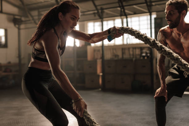 istock Strong woman workout with battle ropes 952328384