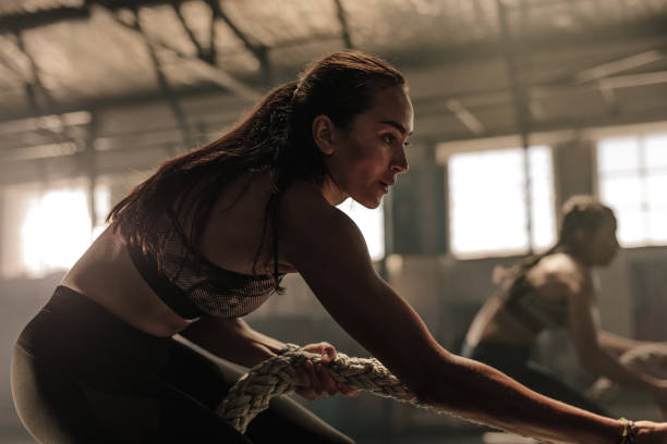 istock Fitness females pulling heavy rope at gym 952329012