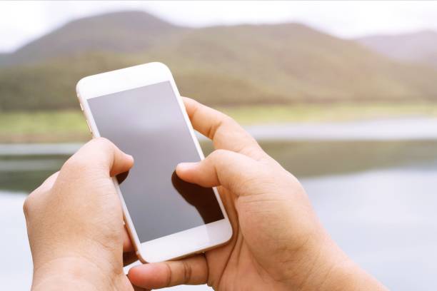 istock view tourist people hands using gadget phone on device on background perspective mountains and sky landscape. finger touch screen cellphone mockup searching for Telephone signal. 952332496