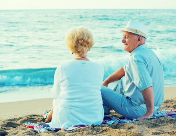 istock Mature man and woman sitting back on towel 952333106