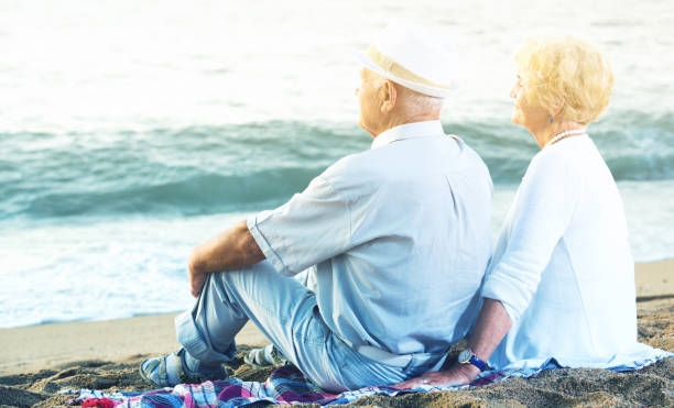istock Mature man and woman sitting back on towel 952333142