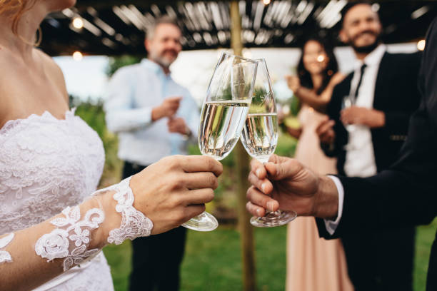 istock Newlyweds clinking glasses at wedding reception 952333940