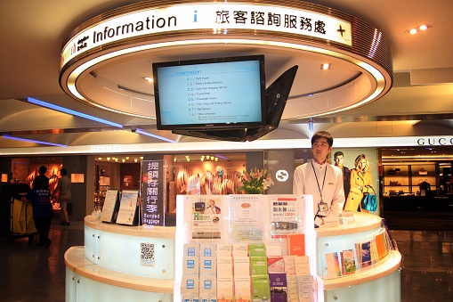 TAIPEI, TAIWAN—AUGUST 2014:  A male assistant waits inside an information booth inside the Taiwan Taoyuan International Airport ready to assist passengers