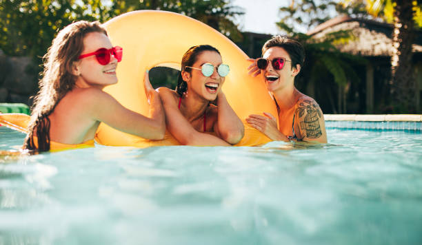 istock Female friends enjoying summer at pool 952336804