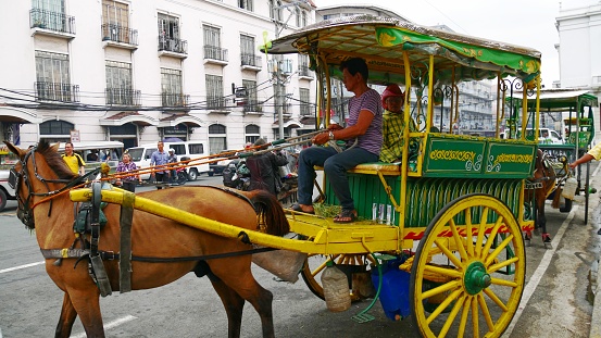 MANILA, PHILIPPINES—AUGUST 2014: A kalesa or horse-drawn carriage at the historic Intramuros area in Manila, Philippines.