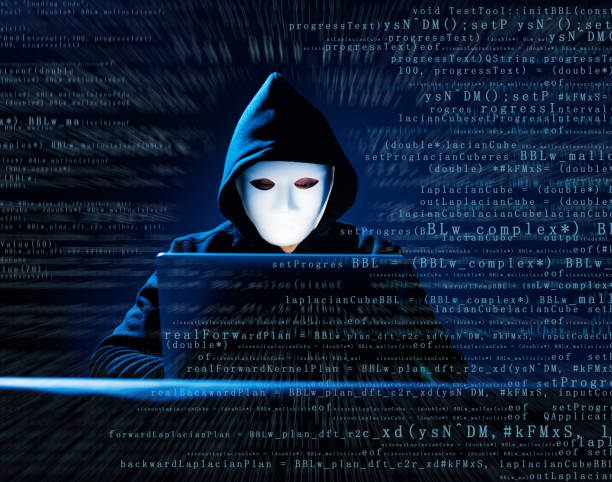 hacher z maską używa laptopa - computer hacker identity security stealing zdjęcia i obrazy z banku zdjęć