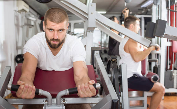 istock Man training on fitness machine in gym 952351592
