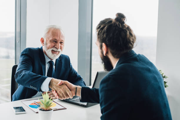 istock Male coworkers shaking hands in office 952357620