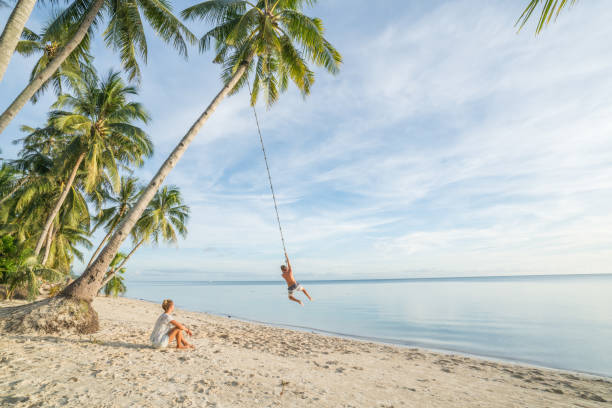 paar am strand, schaukel seil auf palme im tropischen insel asien spielen - seilschaukel stock-fotos und bilder