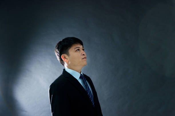 istock Side view of businessman on black background 952370058