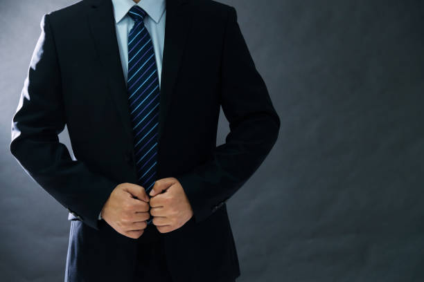 istock Businessman adjusting his suit on black background 952371872