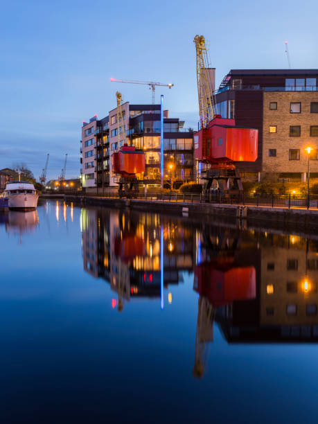 istock Modern riverfront buildings with old dockland cranes 952372220