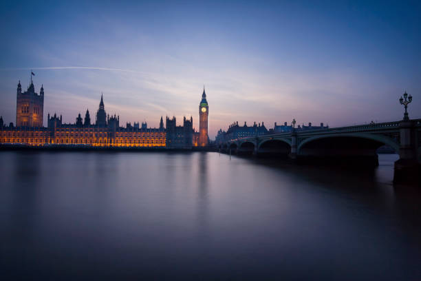 istock Westminster Parliament with Thames in foreground after sunset 952372324