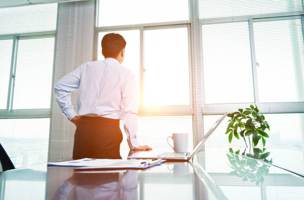 istock Businessman looking out window in office 952375484