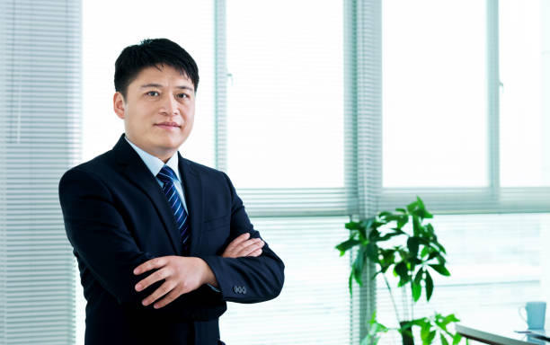 istock Businessman arms crossed standing in office 952375868
