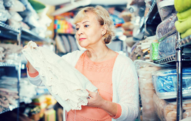 istock customer female choosing cotton tablecloths in the textile store 952376200