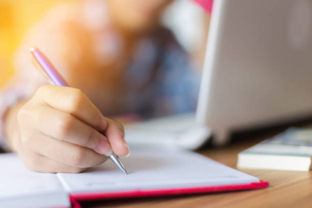 istock female hand write on book for work at home 952379522