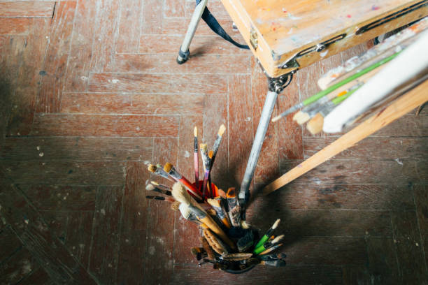 istock Brushes for drawing on an old wooden easel, stand on the floor 952381538